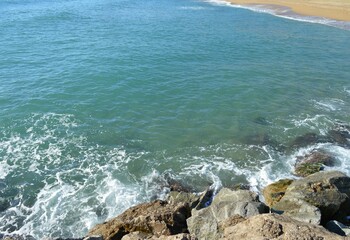 The Mediterranean Sea and the stones on the shore - Barcelona beach and waves of turquoise water