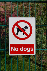 No dogs allowed sign on fence to public park. 