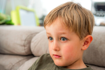 portrait d'un petit garçon souriant, regardant la télévision