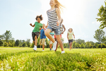 Happy children, playing and running with friends in nature for fun, playful day or sunshine at...