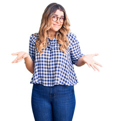 Young caucasian woman wearing casual clothes clueless and confused expression with arms and hands...