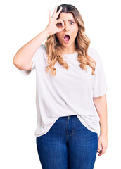 Fototapeta premium Young caucasian woman wearing casual clothes doing ok gesture shocked with surprised face, eye looking through fingers. unbelieving expression.
