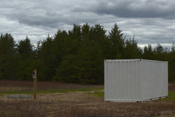 shipping container beside new power hookup in forest