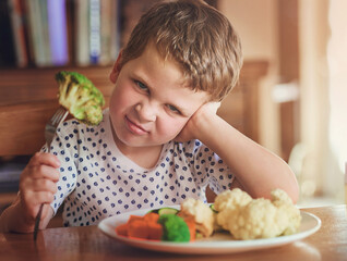 Upset, young boy and reject food at dinner table for not eating vegetable and no to nutrition at...