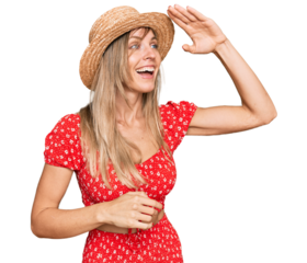 Beautiful caucasian woman wearing summer hat very happy and smiling looking far away with hand over head. searching concept.