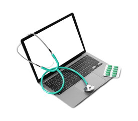 Laptop, stethoscope and pills on white background
