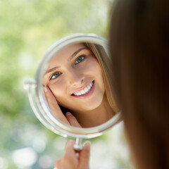 Woman, mirror and anti aging or smile in home, hands and skincare or thinking with natural glowing reflection. Facial wellness, dermatology and cosmetic or inspection, treatment and self care © peopleimages.com