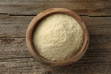 Fresh almond flour in bowl on wooden table, top view