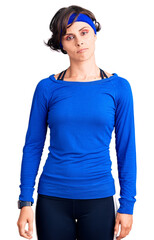 Beautiful young woman with short hair wearing training workout clothes relaxed with serious expression on face. simple and natural looking at the camera.