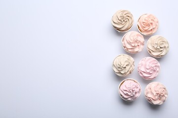 Many tasty cupcakes on white background, flat lay. Space for text