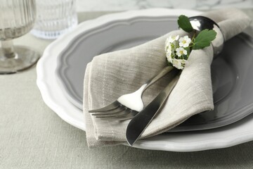 Stylish setting with cutlery and plates on table, closeup