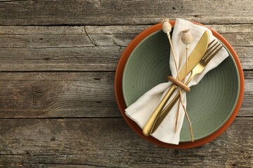 Stylish setting with cutlery, bowl and plate on wooden table, top view. Space for text