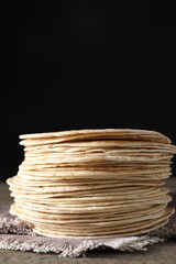 Many tasty homemade tortillas on wooden table, space for text