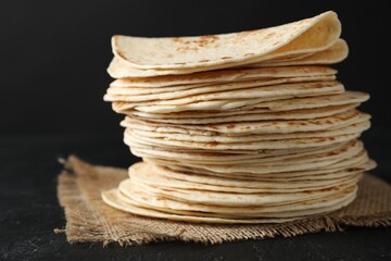 Stack of tasty homemade tortillas on black table