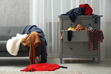 Room and dresser cluttered with clothes. Messy house