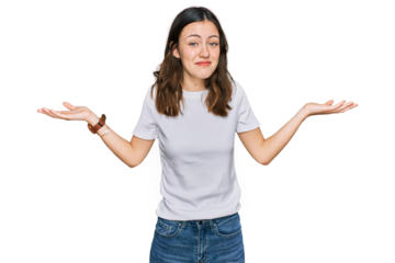 Young beautiful woman wearing casual white t shirt clueless and confused expression with arms and hands raised. doubt concept.