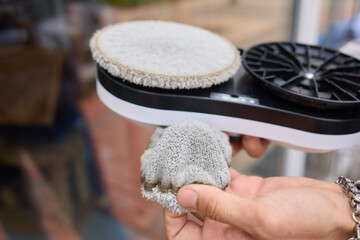 A robotic white Automotive tire is cleaning a glass window replacing cleaning cloths