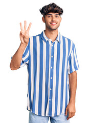 Young hispanic man wearing casual clothes showing and pointing up with fingers number three while smiling confident and happy.