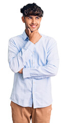 Young hispanic man wearing casual shirt with hand on chin thinking about question, pensive expression. smiling with thoughtful face. doubt concept.