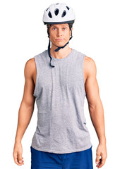 Young handsome man wearing bike helmet depressed and worry for distress, crying angry and afraid. sad expression.