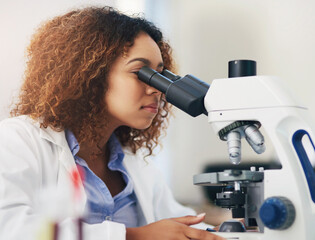 Female scientist, microscope and analyse in laboratory for research or medical breakthrough....