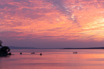 Fishermen's boats on a lake near the coast and the pink sunset
