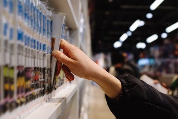 A person is reaching for a book on a shelf in a store