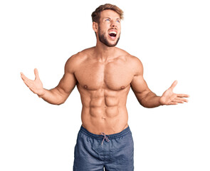 Young caucasian man standing shirtless crazy and mad shouting and yelling with aggressive expression and arms raised. frustration concept.