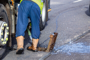 Cleaning municipal sewer: MVC Tanker operative hoses gully drain with water jet