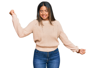 Young latin girl wearing wool winter sweater dancing happy and cheerful, smiling moving casual and confident listening to music