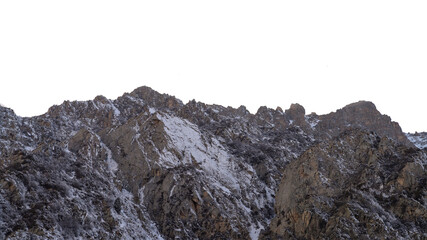 Snow-covered winter high desert dark brown rocks. Isolated landscape.