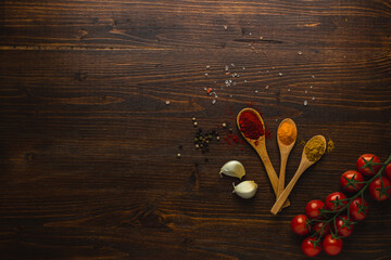 Various Asian spices in wooden spoons on wooden background. Top view