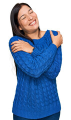 Young hispanic woman wearing casual clothes hugging oneself happy and positive, smiling confident. self love and self care