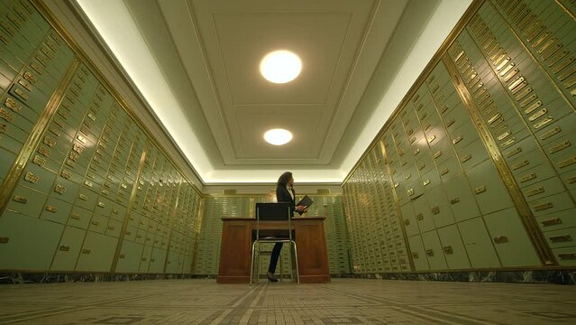 Man sitting at desk in room with lockers, hardwood flooring, and light fixtures