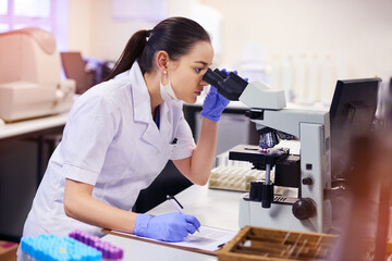 Microscope, female scientist and analyse in laboratory for research or medical breakthrough. Notes,...
