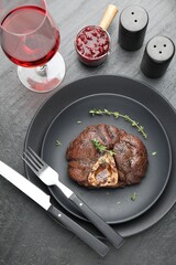 Tasty grilled beef meat served on black table, flat lay