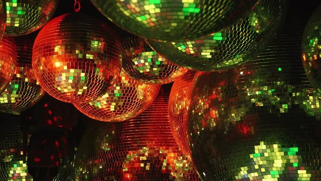 A stunning visual of multicolored disco balls under vibrant spotlights, casting dynamic reflections on a dark background. Part of series Disco Balls Illuminated.