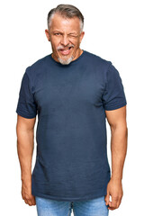 Fototapeta premium Middle age grey-haired man wearing casual clothes winking looking at the camera with sexy expression, cheerful and happy face.