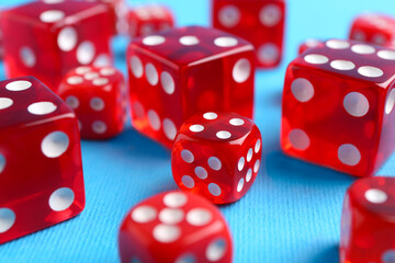 Many red game dices on light blue background, closeup