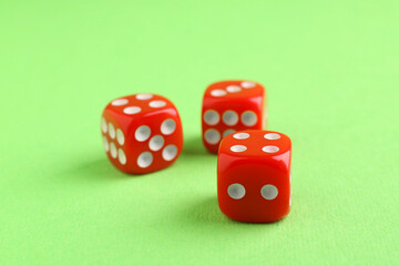 Three red game dices on green background, closeup