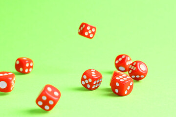 Many red game dices falling on green background