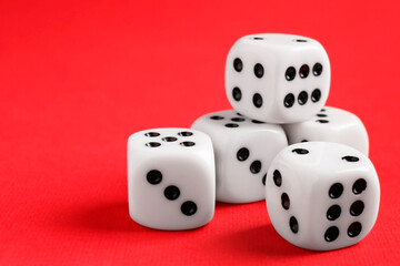 Many white game dices on red background, closeup