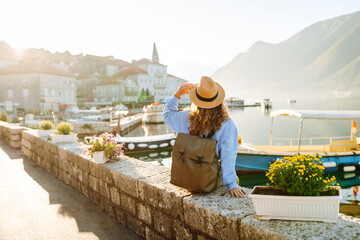 Tourist woman admiring view of colorful the view of the city. Back view. Europe travel. Lifestyle,...