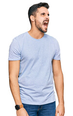 Fototapeta premium Young hispanic man wearing casual clothes angry and mad screaming frustrated and furious, shouting with anger. rage and aggressive concept.