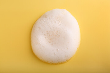 Sample of fluffy foam on yellow background, top view