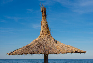 a beach umbrella next to the ocean on a sunny day