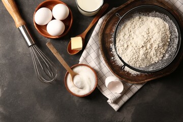Different ingredients for dough on grey textured table, flat lay