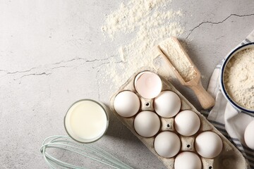 Making dough. Flour, eggs, milk and tools on light textured table, flat lay. Space for text
