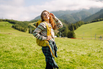 Hiker contemplating mountain views  in a green in a valley. Travel, nature concept.