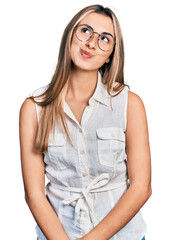 Hispanic young woman wearing casual white shirt smiling looking to the side and staring away...